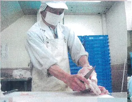 まな板と包丁を使い、鶏を手ばらしする職人